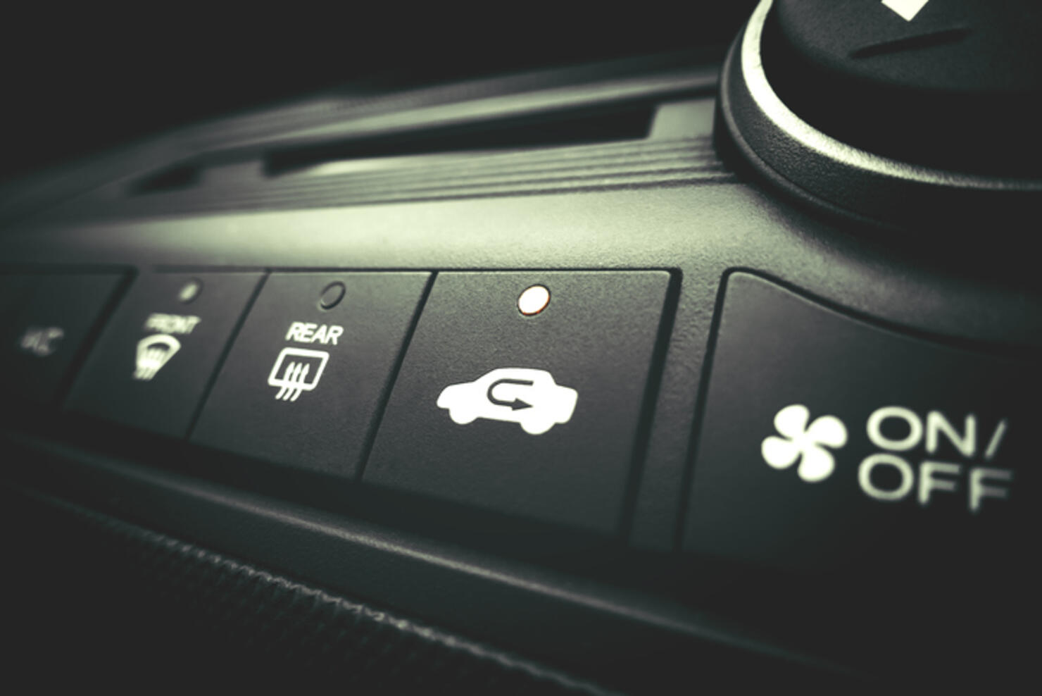 Finger pressing on Power switch of a Car air conditioning system