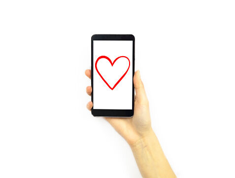 Hand holding a phone with a heart on it