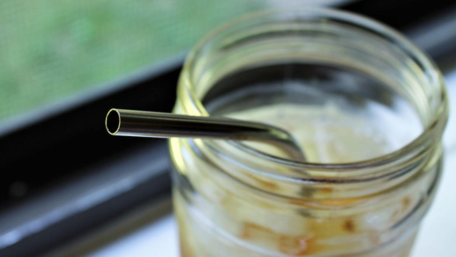 Ice tea in glass with metal straw