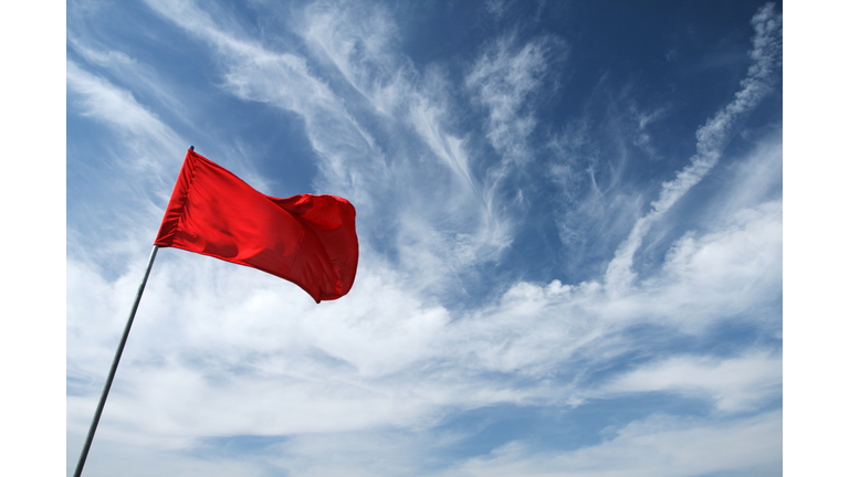 Low Angle View Of Red Flag Against Sky