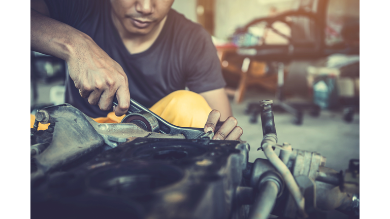 Midsection Of Male Mechanic Repairing Car In Workshop