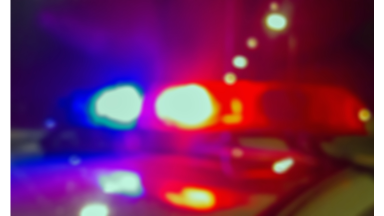 Lights of police car in night time, crime scene. Night patrolling the city, lights flashing. Abstract blurry image.