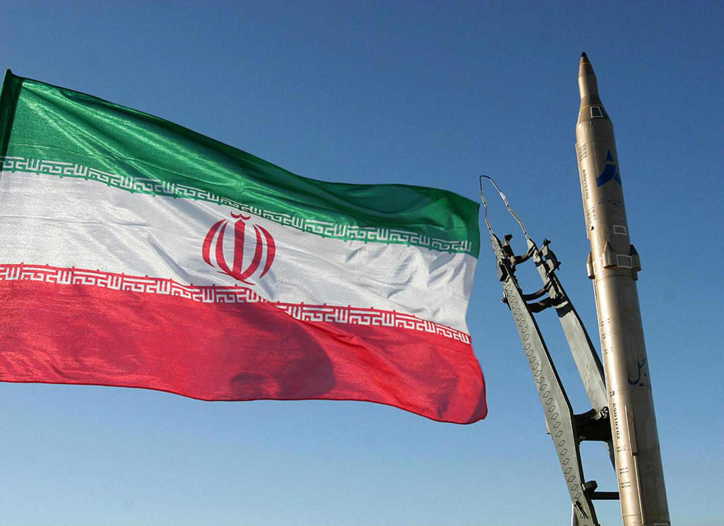 An Iranian flag flutters next to a groun