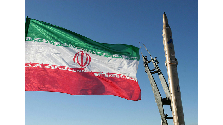 An Iranian flag flutters next to a groun
