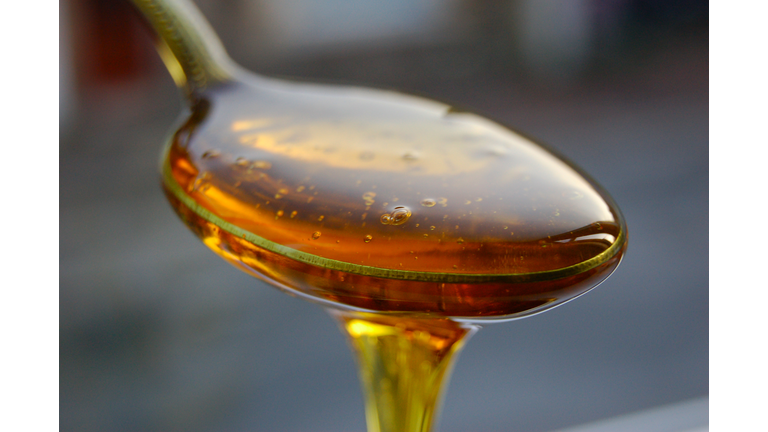 A spoonful of golden syrup overflowing from it