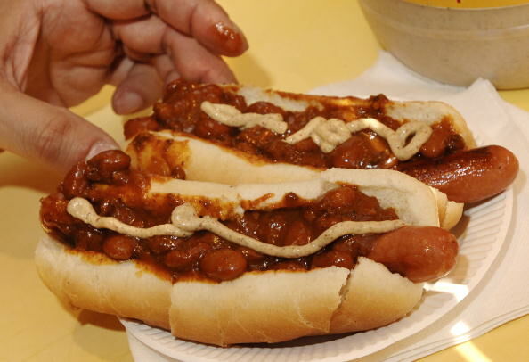 A customer with two hot dogs with chili