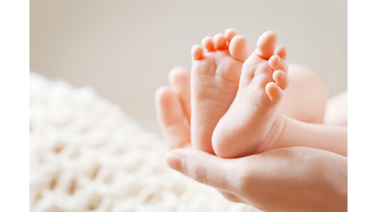 Baby feet in mother hands. Mom and her Child.