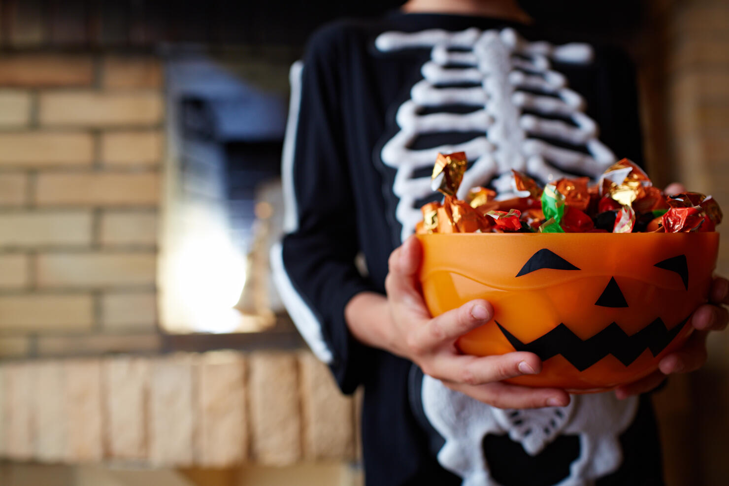 Halloween bowl with chocolate candies given by people