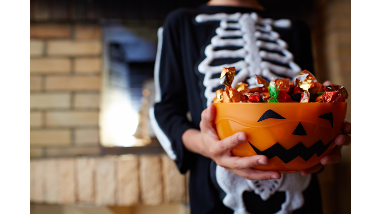 Halloween bowl with chocolate candies given by people