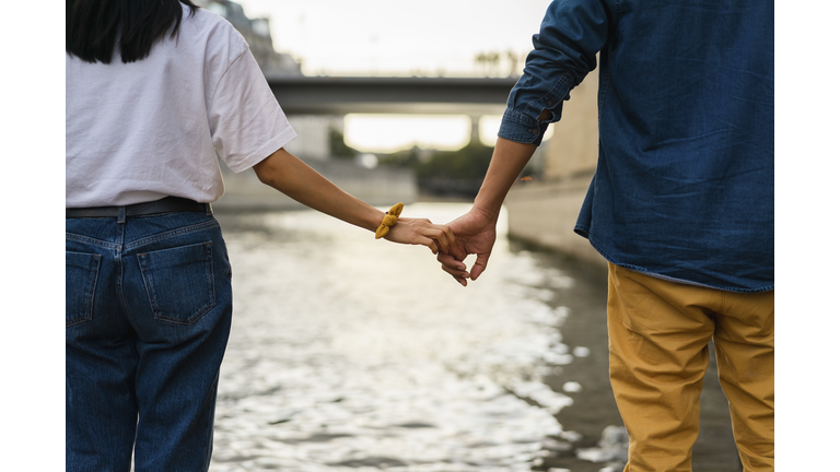 France, Paris, couple holding hands at river Seine