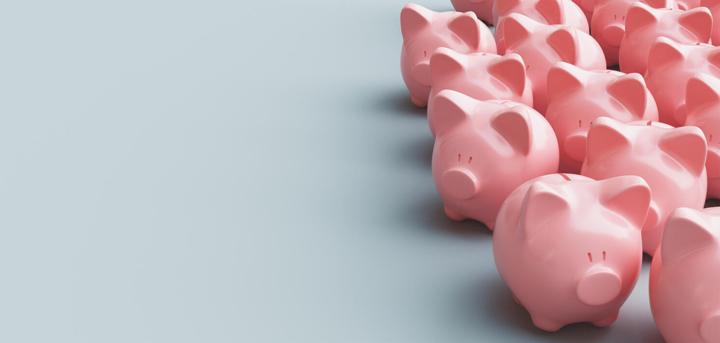 Close-Up Of Piggy Banks Over Gray Background