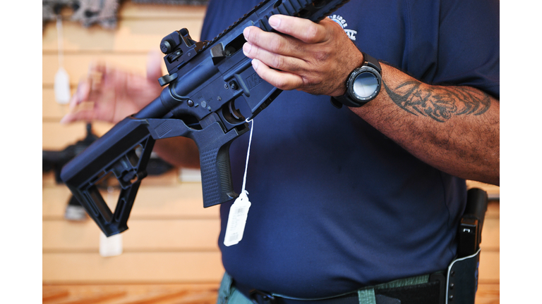 Senior Sales Staff Mark Warner shows a bump stock installed on an AR-15 rifle at Blue Ridge Arsenal in Chantilly, Virgina
