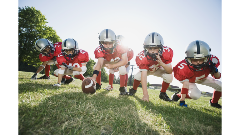 Football players at line of scrimmage ready to snap football