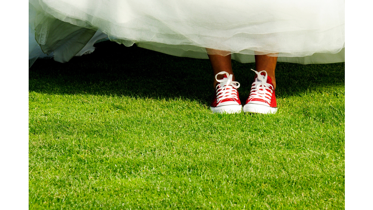 Low Section Of Bride Standing On Grassy Field