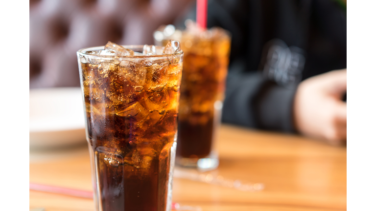 Soft drink on wooden table and men sitting