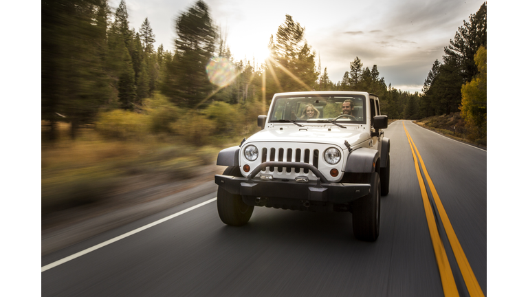 Young couple driving jeep on road trip, Lake Tahoe, Nevada, USA