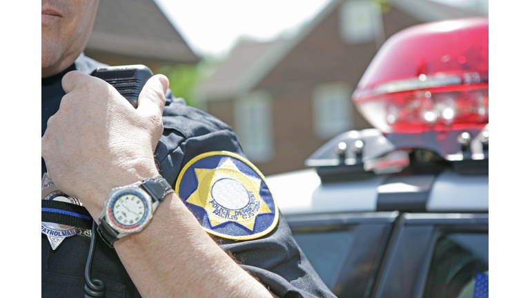 Police officer using radio to call for backup