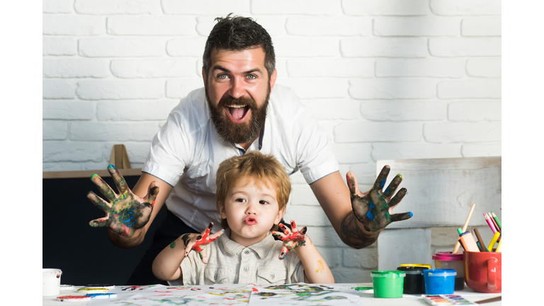 Joy family art, happy father and son show hands in bright colors, paint together picture, art for whole family, cheerful drawing teacher. Home education with parents. Happy childhood. Hands in paint