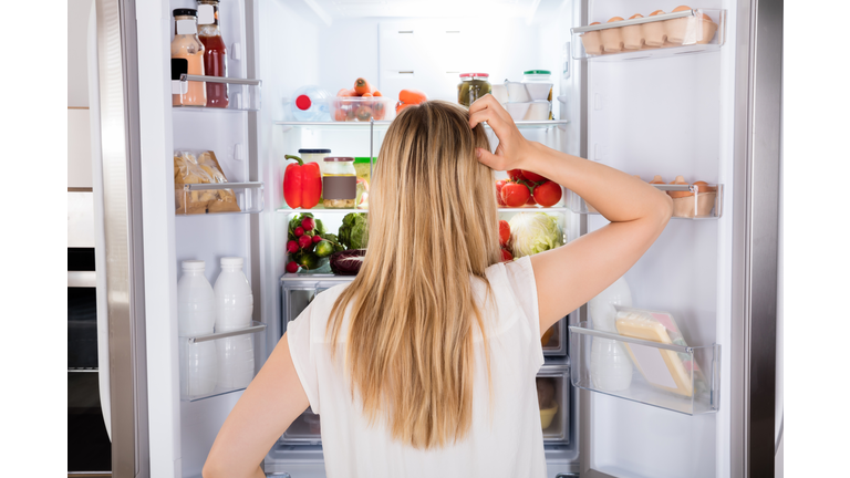 Rear View Of Woman Looking In Fridge