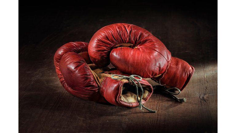 Close-Up Of Red Boxing Gloves Over Wooden Background