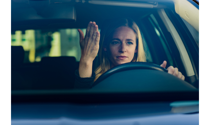Young frustrated woman driving car
