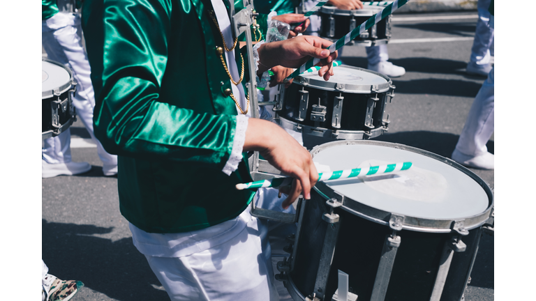 Midsection Of Drummers Playing Drum While Walking On Road