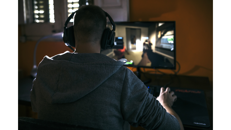 Young man sitting at his PC, playing computer games