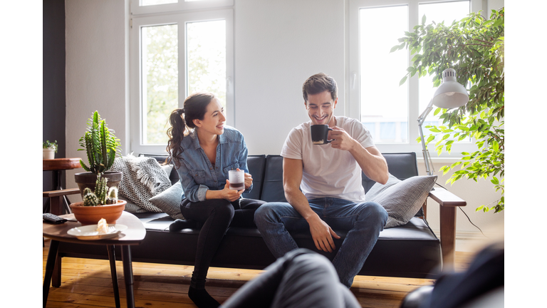 Couple having coffee together in living room