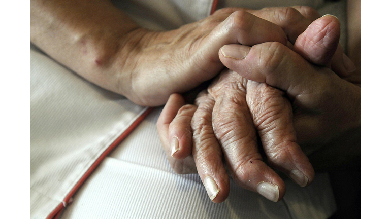A nurse holds the hands of a person suff