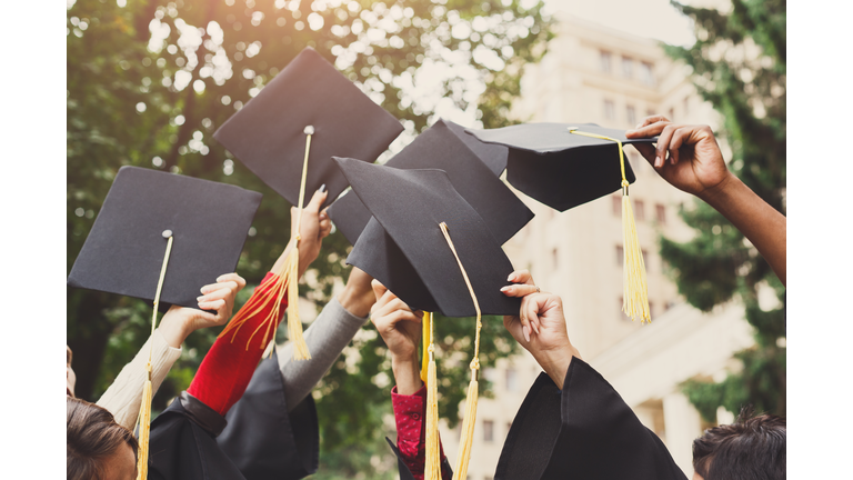 A group of graduates throwing graduation caps in the air