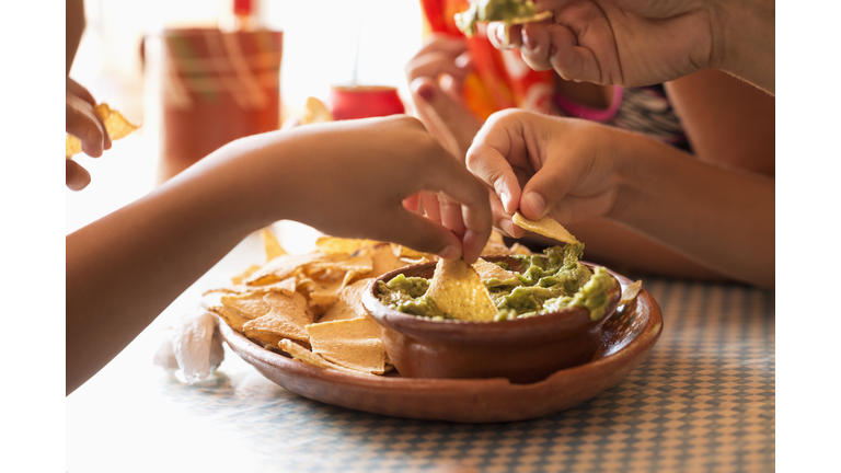 Children eating chips and guacamole