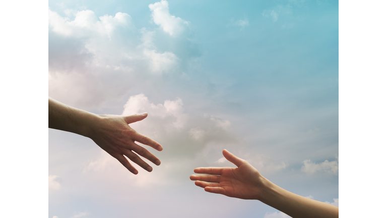 Two hands seem to reach together in the sky