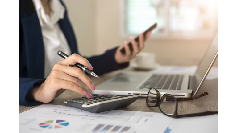 Close up of female accountant or banker making calculations. Savings, finances and economy concept