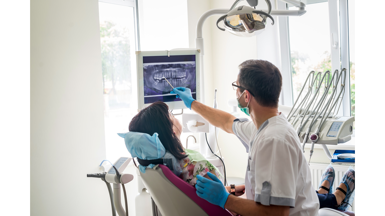 Doctor dentist showing patient's teeth on X-ray