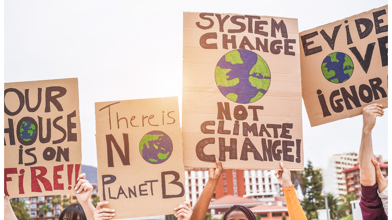 Group of demonstrators on road, young people from different culture and race fight for climate change - Global warming and enviroment concept - Focus on banners