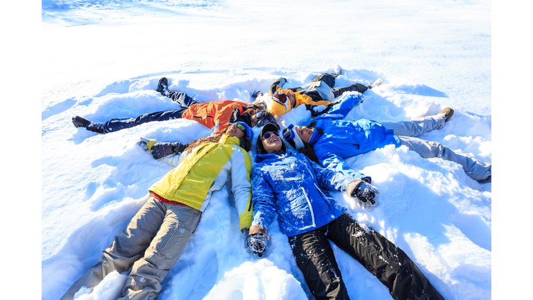 Group of young people making snow angels