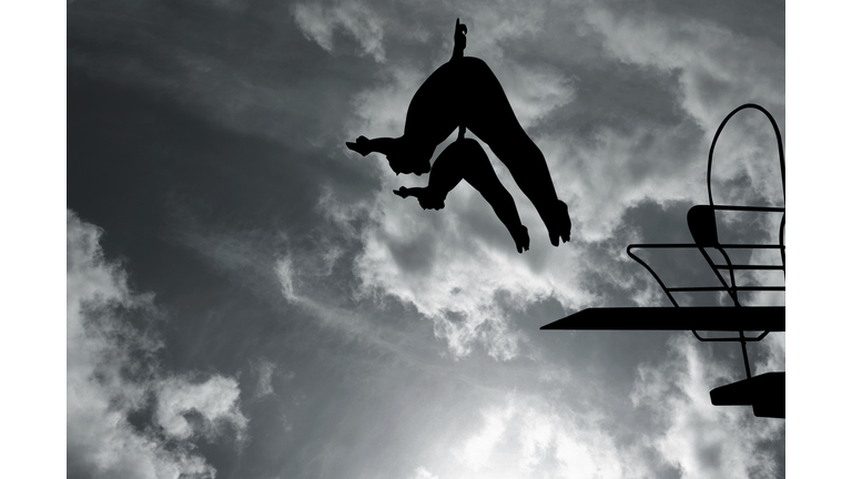 Silhouette of swimmers diving