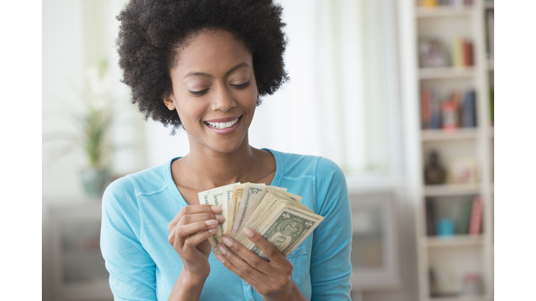 Woman counting money in living room