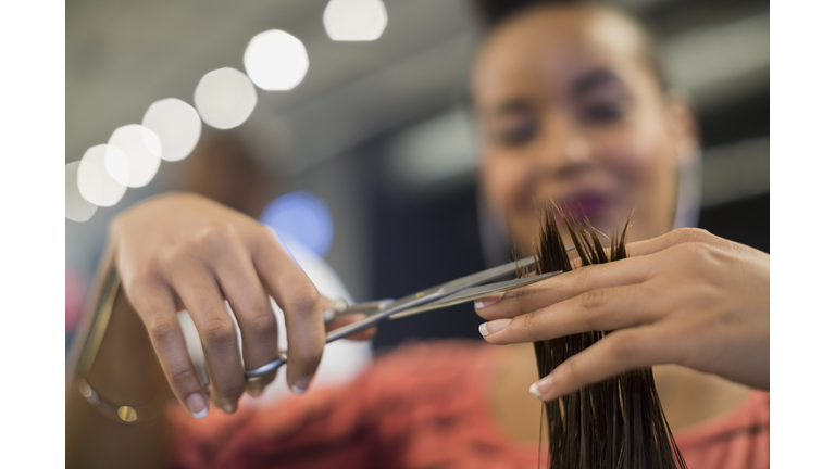 Close up hairstylist cutting hair in hair salon