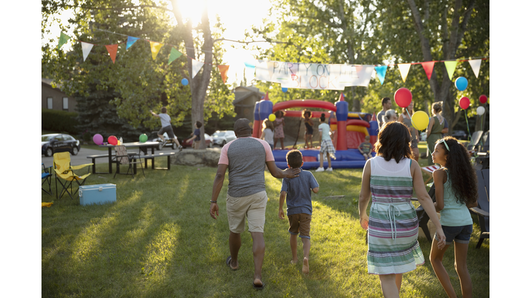 Family arriving at summer neighborhood block party in park