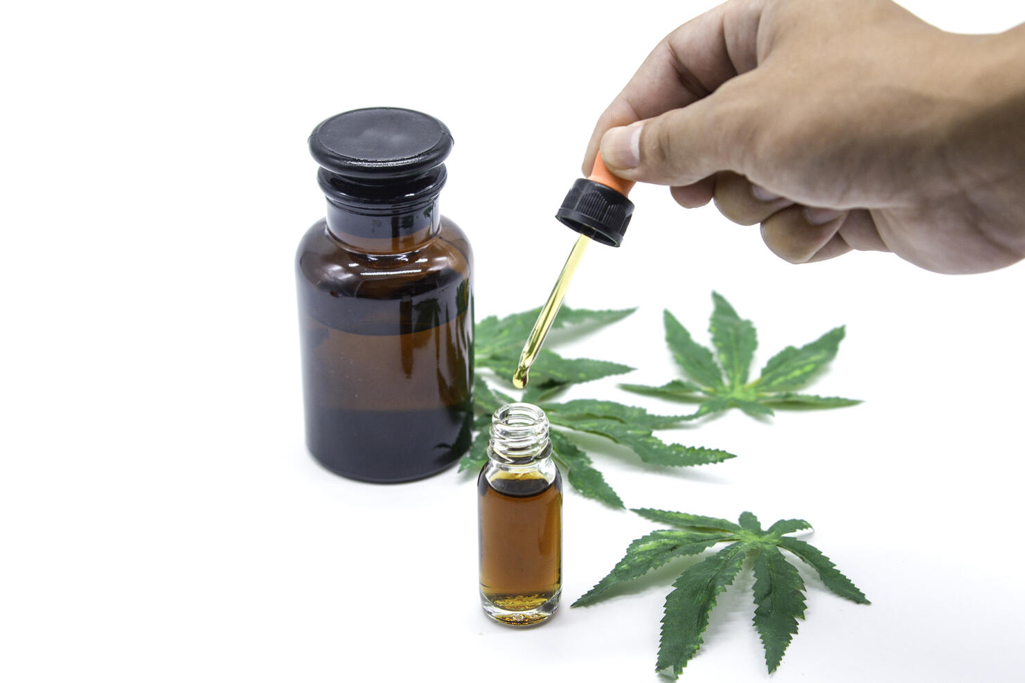 Hand on drop Cannabis oil on white background