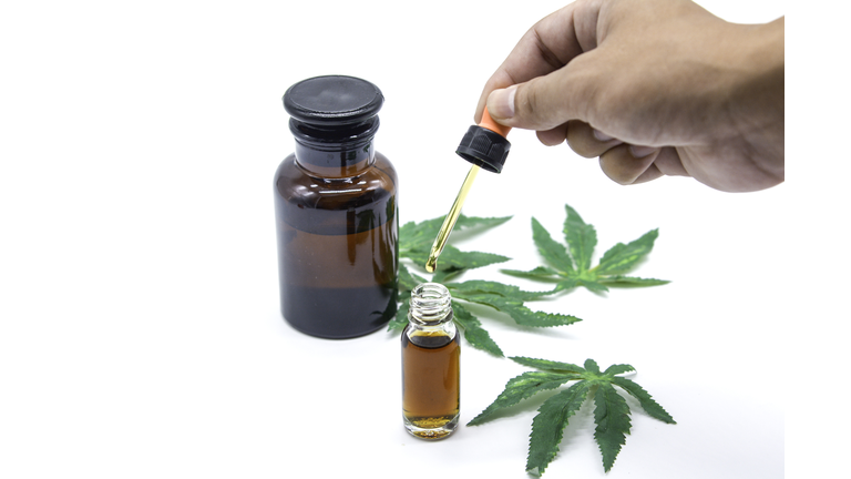 Hand on drop Cannabis oil on white background