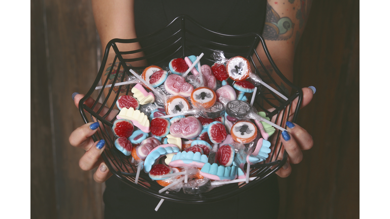 Woman offering Halloween candies, close-up