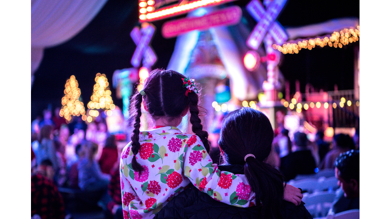 Mother and child are waiting for Santa at a Christmas tree lighting ceremony.