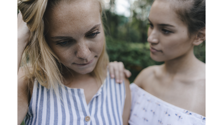 Young woman comforting sad female friend