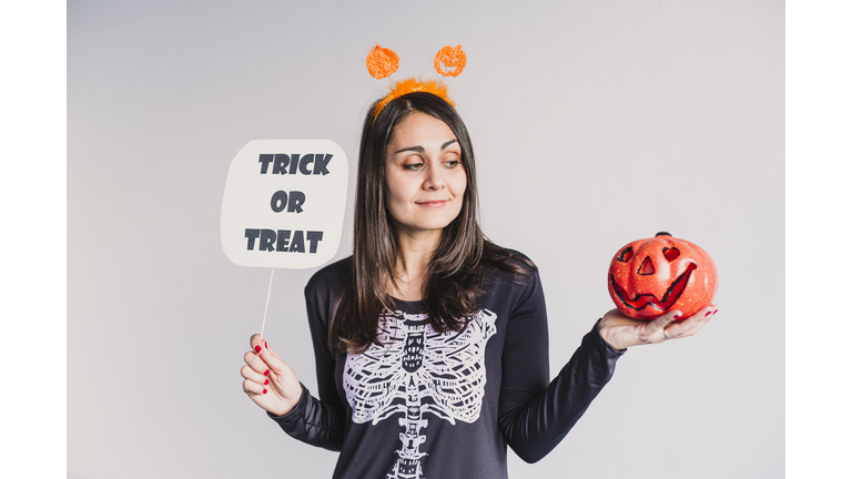 Mid Adult Woman Holding Jack O Lantern Against White Background