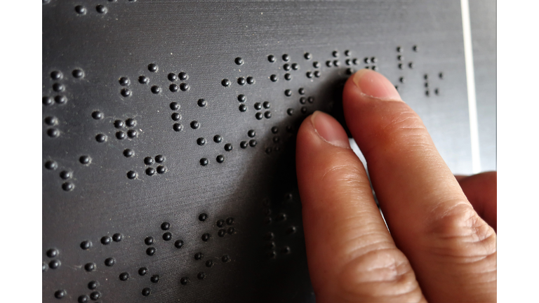 Close up of male hand reading braille text