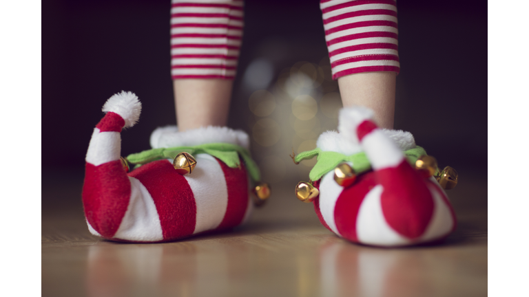 Child wearing Christmas elf novelty slippers with bells