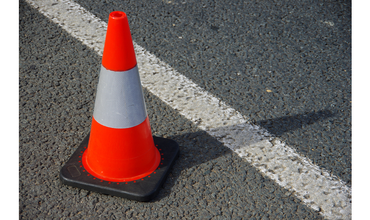 Traffic cone next to the line marking on the shoulder of a road
