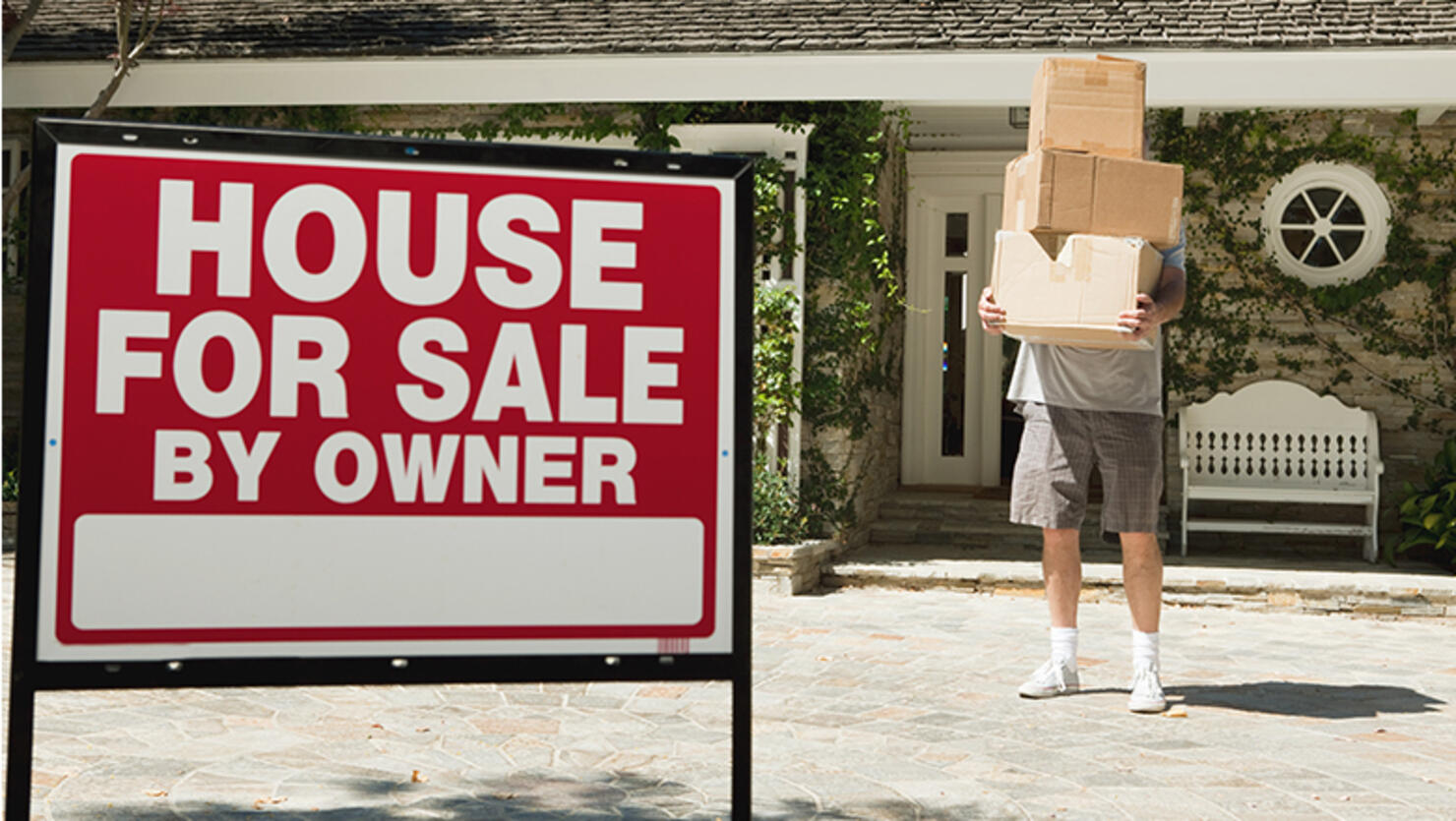 Mature man carrying boxes to move into newly bought property